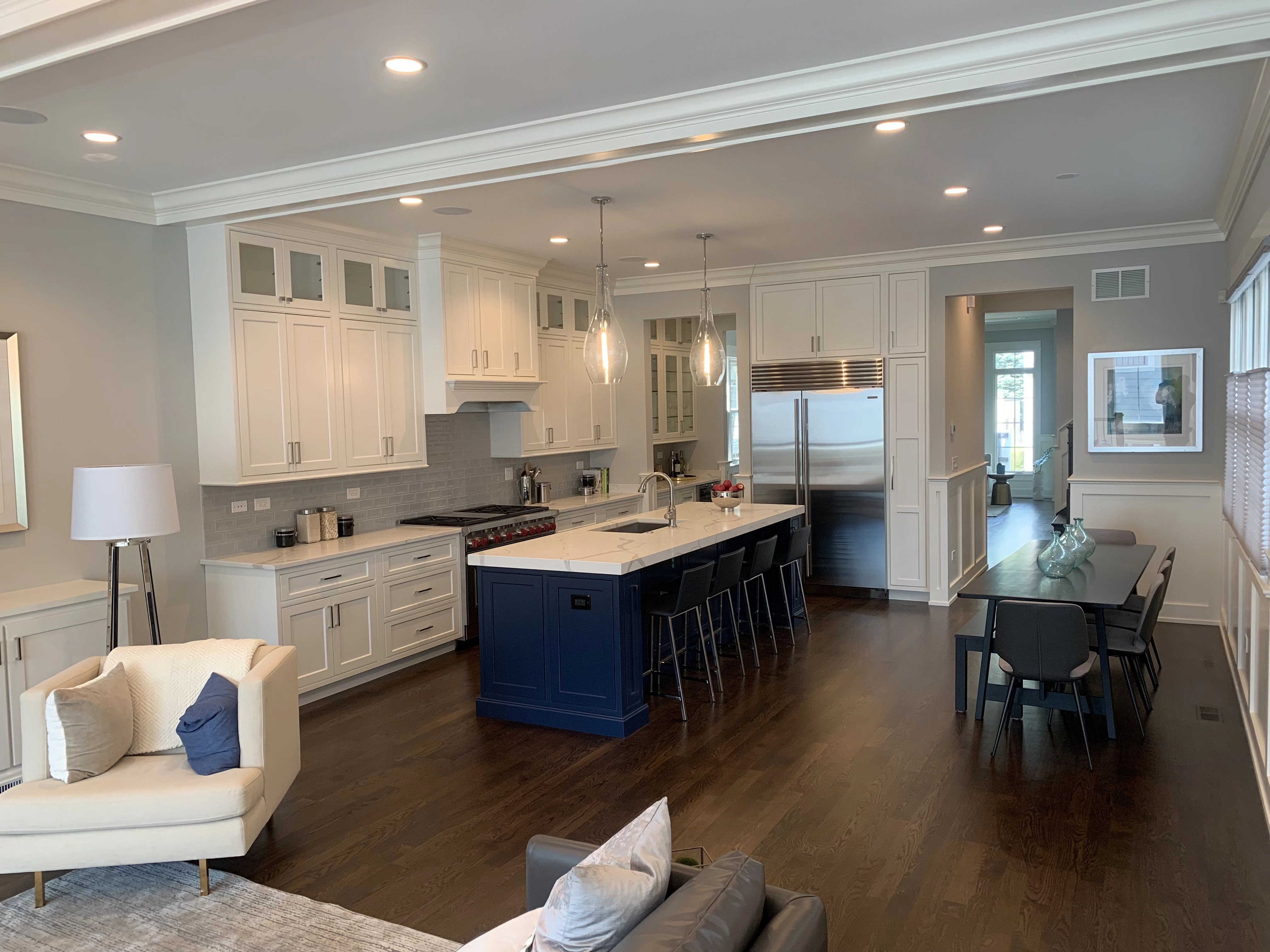 Kitchen with two pendant lamps over island and multiple recessed lights on ceiling