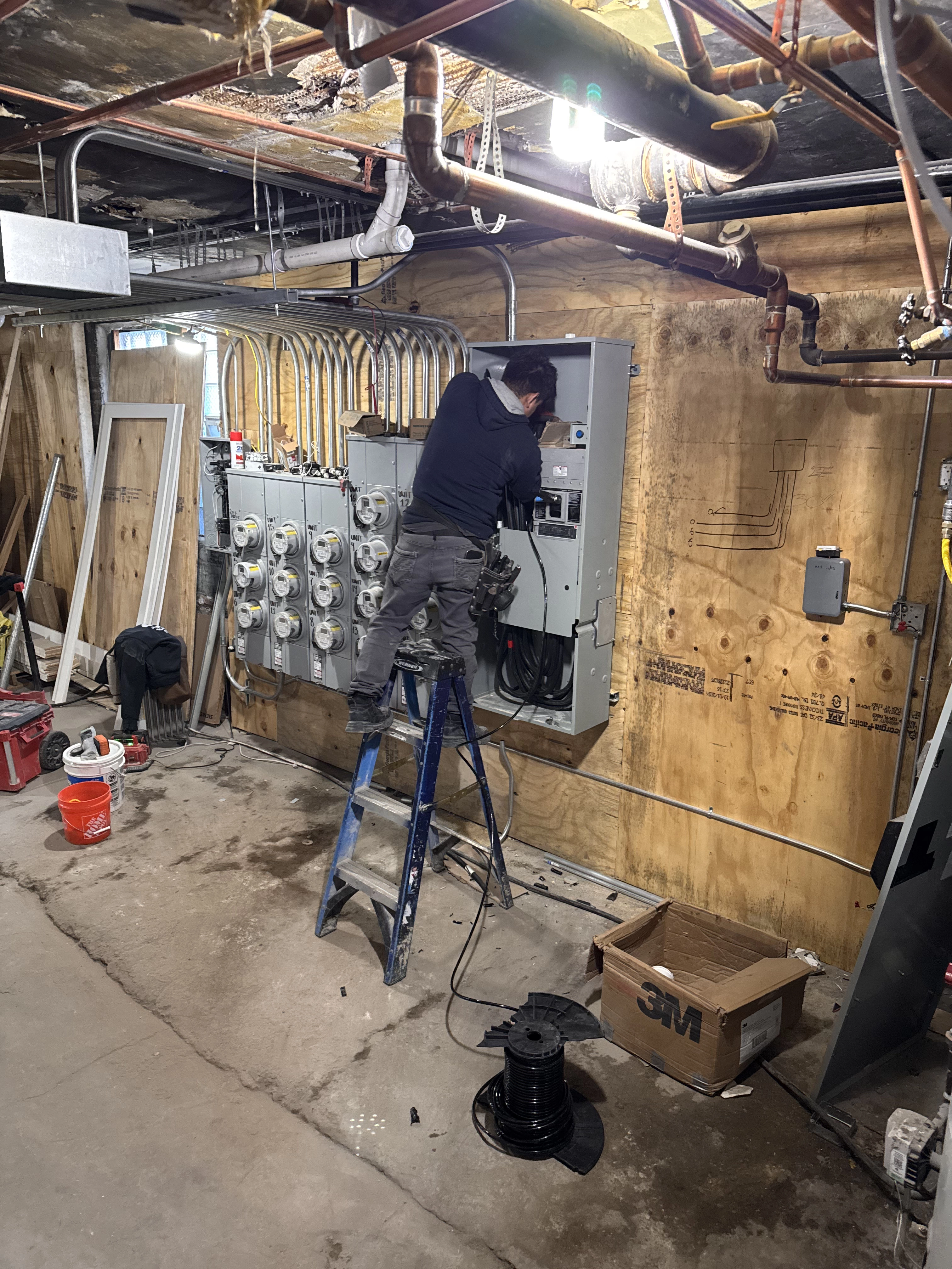 Electrician working on large indoor electrical box